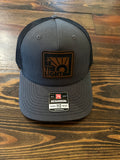 Be the L;ght Trucker Hat in Charcoal/Black